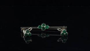 An emerald and diamond bar brooch mounted in white metal, together with a matching pair of screw