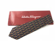 SALVATORE FERRAGAMO - A Salvatore Ferragamo silk tie with gold trophies, red and blue detail, in