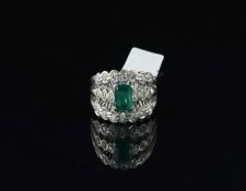 Emerald and diamond ring, central step cut emerald with round brilliant cut diamond detail, in white