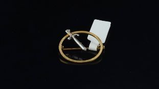 Diamond brooch, yellow metal open circle brooch, with a diamond set dagger through the centre