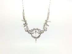 An Edwardian pearl and diamond necklace, in a bow and leaf design, with