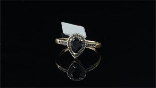 Blue stone and diamond ring, pear cut blue stone, surrounded by diamonds, mounted in yellow metal,