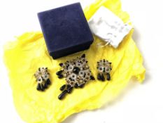 STANLEY HEGLAR- A Stanley Heglar brooch and earring set, yellow metal with black cabochon stones,