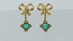 A pair of emerald and diamond drop earrings, designed as a diamond set bow, suspending an emerald