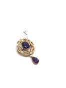 An amethyst and pearl pendant/brooch, central oval cut amethyst, surrounded by seed pearls,