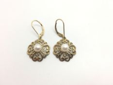 Pair of pearl earrings, single pearl set within a scrolling gold work border, 17mm diameter, in