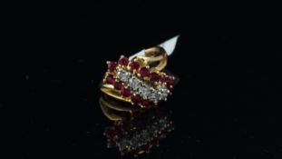 Ruby and diamond ring, twist design with five central round brilliant cut diamonds and surrounded by