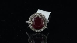 Ruby and diamond cluster ring, central ruby, surrounded by round brilliant cut diamonds, in white