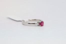 Ruby and diamond three stone ring, round cut ruby to the centre, with a tapered baguette cut diamond