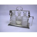 An Electroplate Tantalus the lockable top centred with a carrying handle, containing three clear