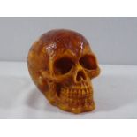 Amber coloured skull approx. 5" high with tribal style decoration