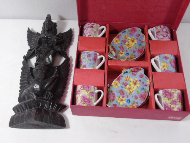 Carved oriental god figure and a boxed set of cups and saucers