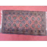 Small red and brown handmade Persian rug with frin