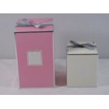 2 Boxed scented candles 1 pink candle and 1 white