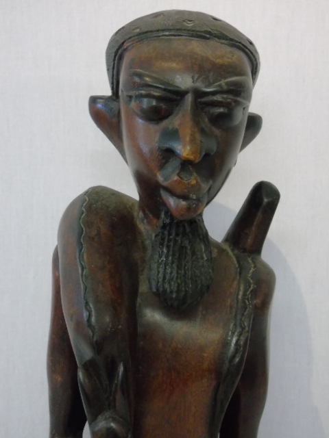 Large carved figure of a tribal man carrying his kill approx. 29" tall