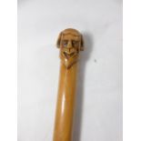 Carved hard wood cosh with a carved head top approx. 21.5" long