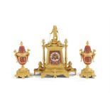 A late 19th century French Egyptian Revival gilt bronze and bisque porcelain mounted clock garniture