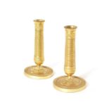 A pair of Empire gilt brass dwarf candlesticks