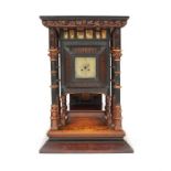 A large late 19thc oak, ebony, boxwood and parcel gilt mantel clock in the manner of Bruce Talbert