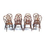 A matched set of eight George IV ash, elm and beech Gothic Windsor chairs, Buckinghamshire