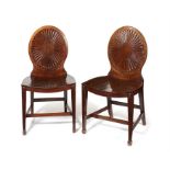 A pair of George III carved mahogany and purplewood inlaid hall chairs