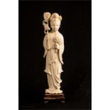 A 19th century ivory carved geisha girl holding lotus flowers, raised on a carved base, 29cm high.