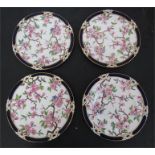 A set of four hand painted porcelain plates, depicting peonies, bees and butterflies with a cobalt