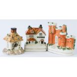 A group of three 19th century Staffordshire pastille burners in the form of houses; one a castle.