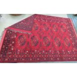 An antique wool hand woven Eastern rug, red ground with stylised motifs, 10ft4 by 7ft.