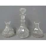 A cut glass decanter with original stopper and two further small decanters.