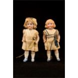 Two miniature porcelain dolls.