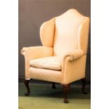 A 19th century wing arm chair, with camel back, raised on four cabriole legs.