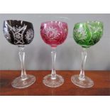 Three cut glass coloured wine glasses.