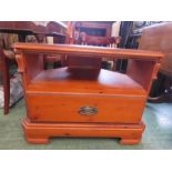 A varnished pine television stand with drawer and shelf.