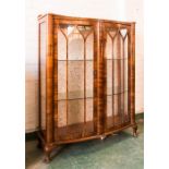 A 1930s glazed cabinet, mahogany with bowed doors.