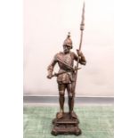 A bronzed figure of a knight with lance.