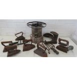 A group of antique flat irons, trivets and oil bur