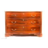 A Georgian mahogany serpentine commode/chest of drawers, the three graduated drawers rasied on