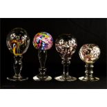 A group of four glass paperweights on knopped stem