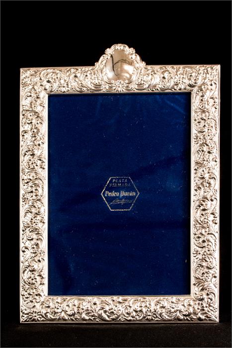 A silver frame marked 925, embossed with scrollwor