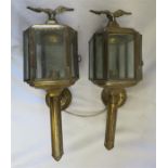 A pair of brass carriage lanterns with eagle finia