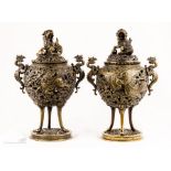 A pair of bronze urns with bird form finials.