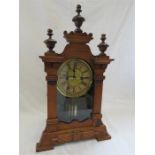 A mahogany mantle clock with roman numeral dial.