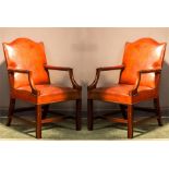 A pair of red leather Gainsborough chairs.