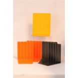 Two pairs of acrylic bookends in orange and black; 12.5cm high and one yellow metal bookend; 15cm