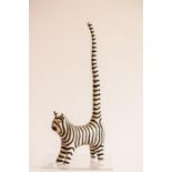 A wooden model of a stripey cat with upright tail, initialled WT, 31cm tall.