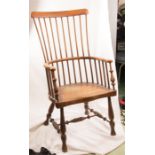 A 19th century stick back Windsor chair with shaped slab seat, turned legs and H Stretcher, possibly