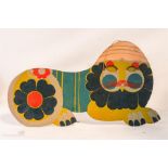 A 2D hand painted wooden lion, labelled Atelier Daniel Mermes, St Lucian with articulated eyes.