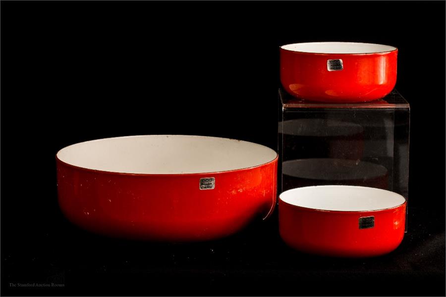 A trio of red enamel bowls with label 'Arabia Finland', one large, diameter 26cm two smaller bowls