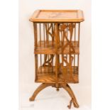 An Arts & Crafts marquetry revolving bookcase, in the style of Galle design, with pierced and carved